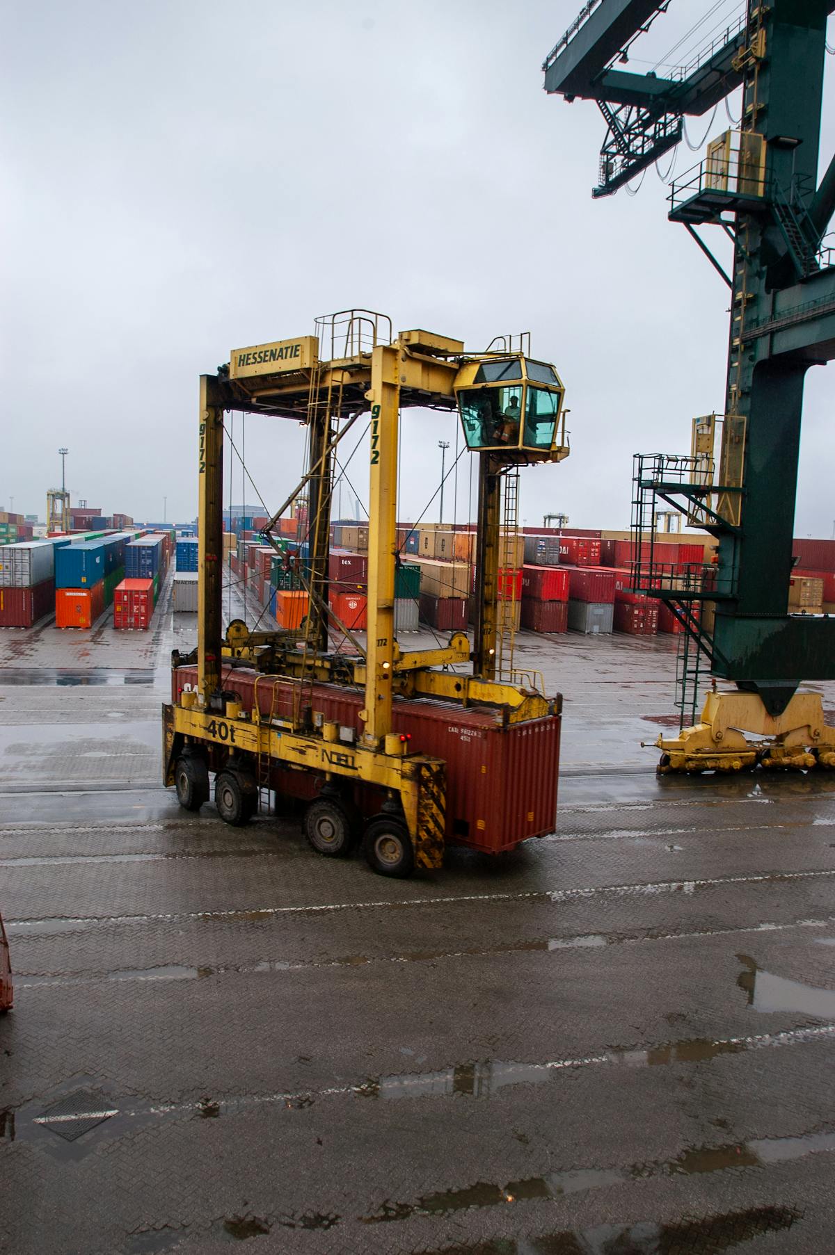 Straddle carrier moving container at port